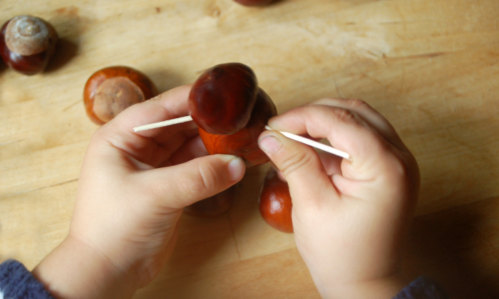 Kind bastelt mit Kastanien © thingamajiggs/Adobe Stock