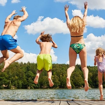 Familie springt in einen See
